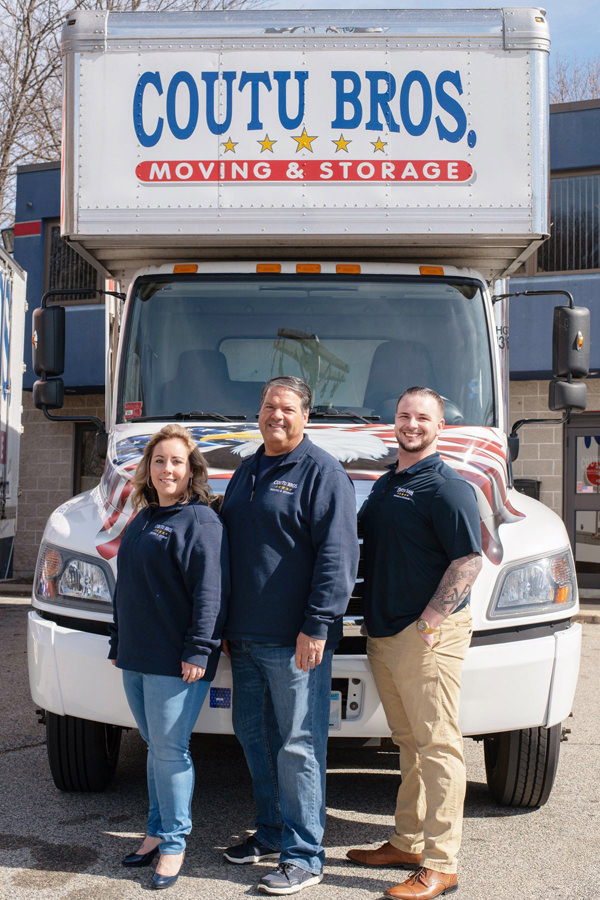 Three Team Members Standing in Front of Moving Truck